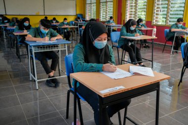 Muadzam Şah, Malezya - 8 Temmuz 2020: Malezyalı öğrenciler Covid -19 'dan korunmak için okulda yüz maskesi ve yüz maskesi takıyorlar. Yeni normal eğitim.