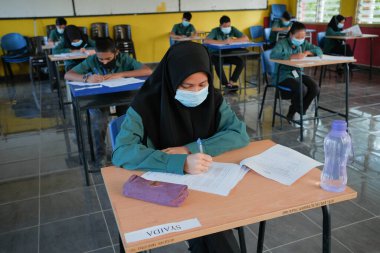 Muadzam Şah, Malezya - 8 Temmuz 2020: Malezyalı öğrenciler Covid -19 'dan korunmak için okulda yüz maskesi ve yüz maskesi takıyorlar. Yeni normal eğitim.