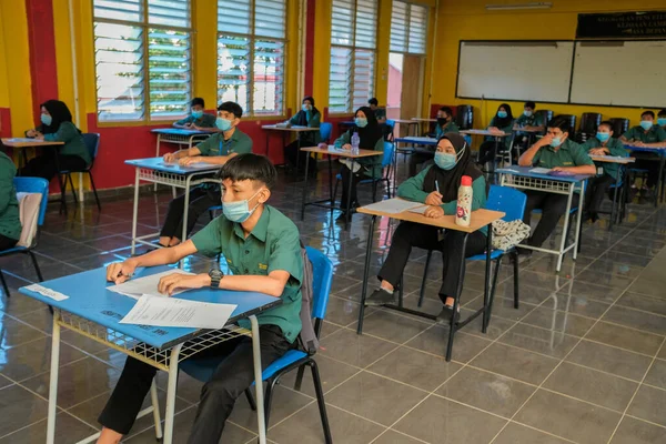 Muadzam Şah, Malezya - 8 Temmuz 2020: Malezyalı öğrenciler Covid -19 'dan korunmak için okulda yüz maskesi ve yüz maskesi takıyorlar. Yeni normal eğitim.