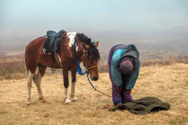 Bromo, Endonezya - 3 Ağustos 2019 Teletubbies Hill ve Savana 'da bir adam ve atı (Bromo Tengger Semeru Ulusal Parkı)