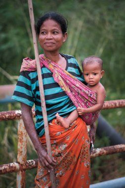 Muadzam Şah, Malezya - 21 Eylül 2020: Aborjin anne batik sarung giyip bebek taşıyor