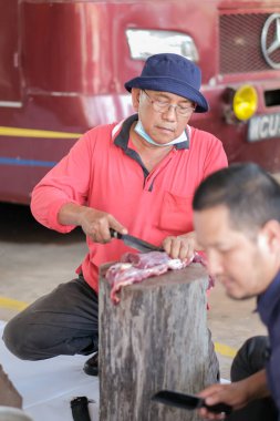 Muadzam Şah, Malezya - 10 Ağustos 2020: Keskin bir bıçakla et yığını oyan kimliği belirsiz adam
