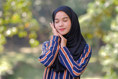 Açık havada tesettürlü sevimli Malezyalı kadın portresi.