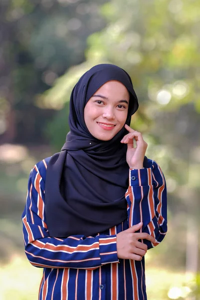 Portrait of cute Malay Asian lady wearing hijab outdoor.