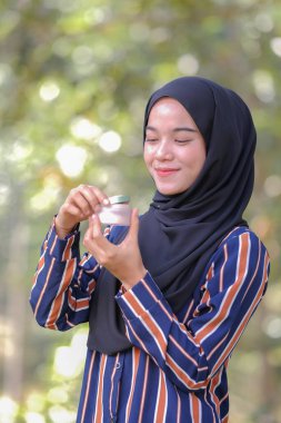 Yüzüne makyaj yapan tesettürlü yakın plan kadın modeli. Makyajla yüzüne fondöten güzel bir genç kadın. Moda ve güzellik konsepti