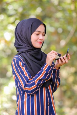 Güzel genç bir kadın fırça ve güzellik konsepti kullanarak yüzüne allık sürüyor.