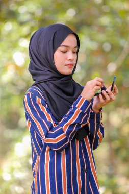 Güzel genç bir kadın fırça ve güzellik konsepti kullanarak yüzüne allık sürüyor.