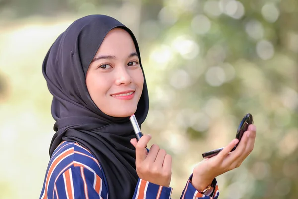 Sırıtkan Genç Güzel Tesettürlü Ruj Ayna Tutan Müslüman Bir Kadın — Stok fotoğraf