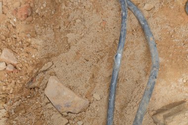 Elektrik kablosu tamiri, altında hasarlı kabloyla açık siper. .