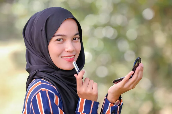 Sonriente Hermosa Joven Musulmana Con Hijab Sosteniendo Lápiz Labial Espejo —  Fotos de Stock