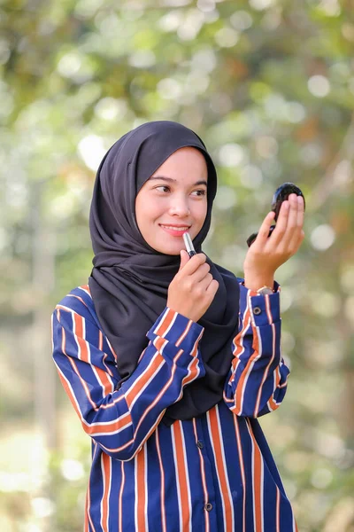 Sonriente Hermosa Joven Musulmana Que Usa Hijab Aplicando Lápiz Labial —  Fotos de Stock