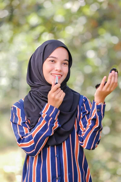 Sonriente Hermosa Joven Musulmana Que Usa Hijab Aplicando Lápiz Labial —  Fotos de Stock