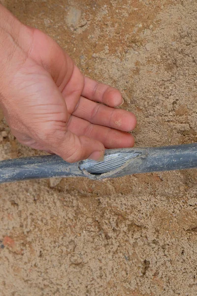 Elektrik kablosu tamiri, altında hasarlı kabloyla açık siper. .