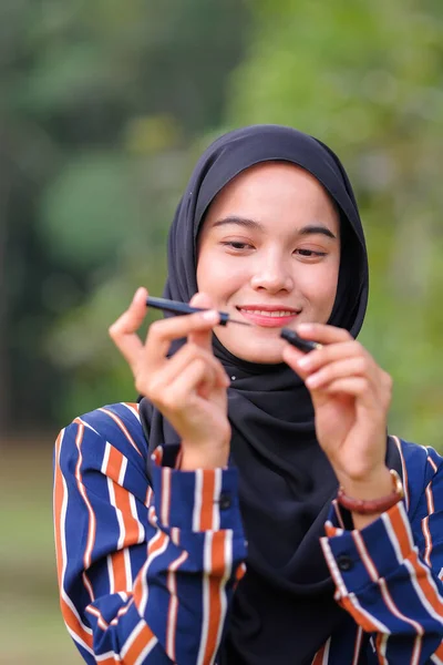 Gadis Hijab Cantik Mengenakan Gaun Modern Memegang Eyeliner Atas Latar — Stok Foto