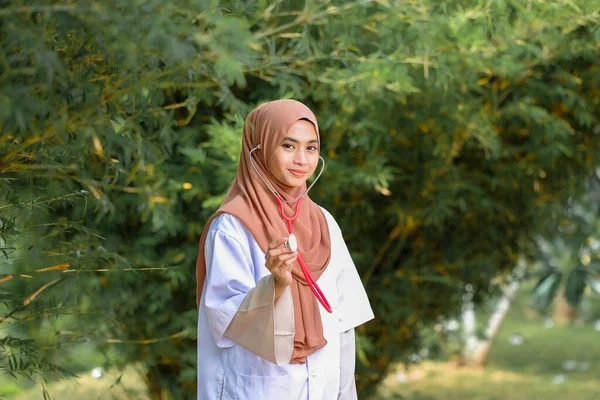 Potret Dokter Wanita Tersenyum Memegang Stetoskop Saat Berdiri Dekat Pohon — Stok Foto