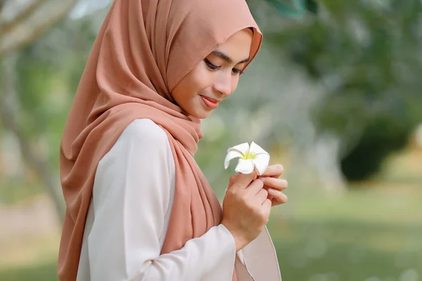 Красивая Мусульманка Стоит Деревом Держит Белый Цветок — стоковое фото