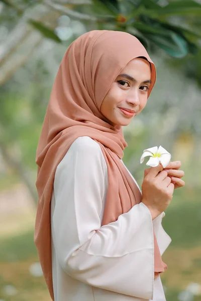 Bastante Musulmana Hembra Pie Bajo Árbol Sosteniendo Flor Blanca —  Fotos de Stock