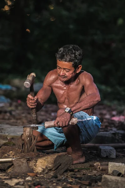 Indigenous Malaysian aboriginal craftman making a spear for hunting.