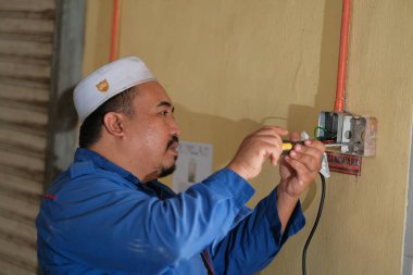 Muadzam Şah, Malezya - 28 Eylül 2020: Elektrikçi atölyenin duvarına soket kutuları yerleştirdi.