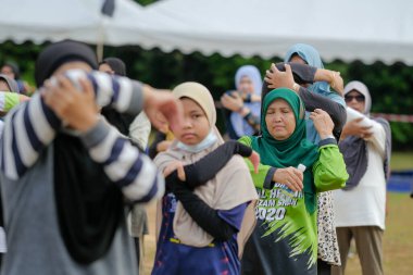 Muadzam Şah, Malezya - 16 Eylül 2020: Bir grup Asyalı aile babası, anne ve kızı koşuya çıkmadan önce esniyorlar.