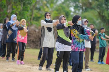 Muadzam Şah, Malezya - 16 Eylül 2020: Bir grup Asyalı aile babası, anne ve kızı koşuya çıkmadan önce esniyorlar.