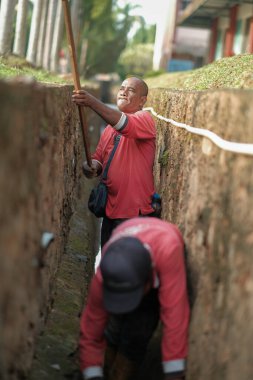 Muadzam Şah, Malezya - 1 Ekim 2020: Kimliği belirsiz işçiler gideri temizliyor. Kanalizasyon sisteminde sorun var.
