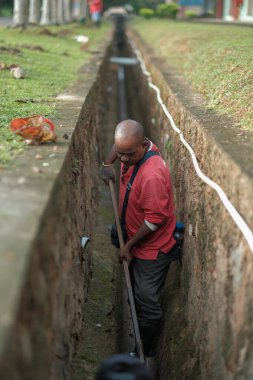 Muadzam Şah, Malezya - 1 Ekim 2020: Kimliği belirsiz işçiler gideri temizliyor. Kanalizasyon sisteminde sorun var.