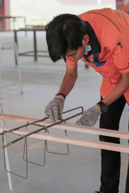 Muadzam Şah, Malezya - 29 Eylül 2020: Konut İnşaat stajyeri atölyede demir parmaklıkları bağlıyor.