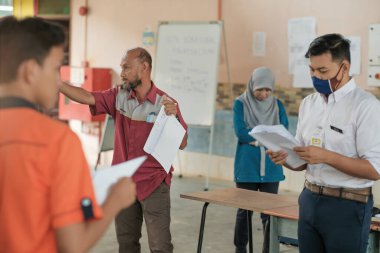 Muadzam Şah, Malezya - 29 Eylül 2020: Konut İnşaat stajyeri ve eğitmeni atölyede demir parmaklıkları bağlıyor.