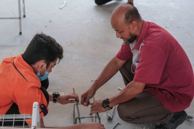 Muadzam Şah, Malezya - 29 Eylül 2020: Konut İnşaat stajyeri ve eğitmeni atölyede demir parmaklıkları bağlıyor.