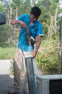 Muadzam Şah, Malezya - 3 Ekim 2020: Asyalı erkek teknisyen, havalandırmayı içeride temizliyor.