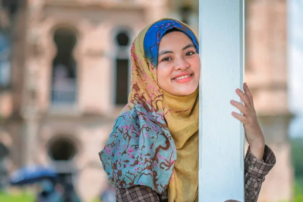レンガ造りの建物の背景にヒジャーブの若い美しいアジアのイスラム教徒の女性の肖像 — ストック写真