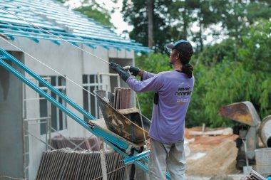 Muadzam Şah, Malezya - 3 Ekim 2020: İşçi işçi kaldırım kiremitlerini kova ve ip kullanarak taşıyor bina çatıları kurun