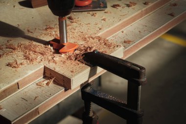 Forstner parçası, sürgülü kapı silindiri, işaretleme göstergesi, vidalar ve ahşap işçilerinin masasında kare deneyin