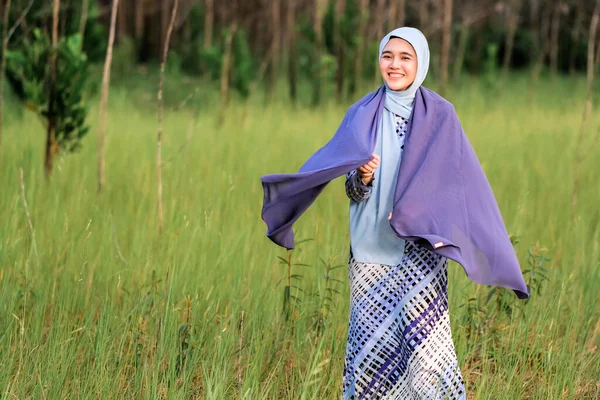 Elinde Kumaş Tutarken Yeşil Alanda Poz Veren Şık Tesettürlü Genç — Stok fotoğraf