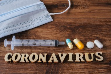 Tahta arka planda tıbbi ekipmanlarla Coronavirus yazıları. Roman Coronavirus 2019-nCoV Orta Doğu Solunum Sendromu Coronavirüs.