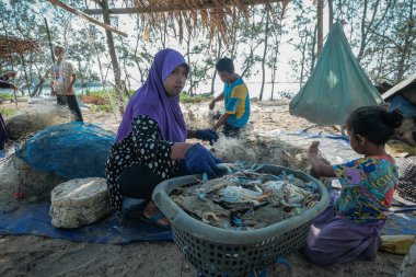 Kuala Rompin, Malezya - 30 Ağustos 2020: anne ve baba balıkçı iskelesinden taze yengeç alıyor.