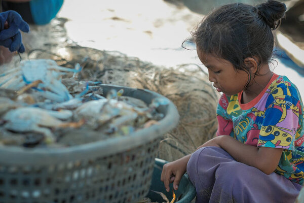 Куала-Ромпин, Малайзия - 30 августа 2020 года: Молодая азиатская девочка и краб в рыбацкой деревне Куала-Ромпин