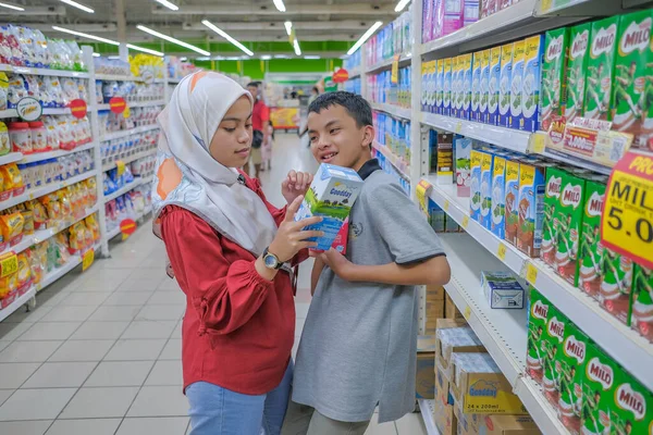 マレーシアのムアドザムシャー 2020年3月8日 スーパーマーケットで買い物をする10代の若者は 製品情報を読み 牛乳を保持し 価格と品質を比較し カジュアルな服を着て 魅力的な外観を持っています — ストック写真