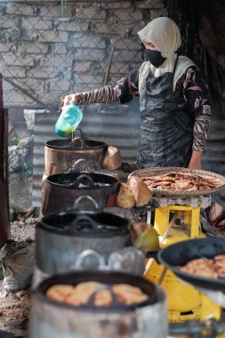 Kota Bharu, Malezya - 3 Temmuz 2020: Yakıt olarak hindistan cevizi kabukları kullanarak Malezya 'da yerel bir çöl yapan karı ve kocanın portresi.