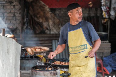 Kota Bharu, Malezya - 3 Temmuz 2020: Yakıt olarak hindistan cevizi kabukları kullanarak Malezya 'da yerel bir çöl yapan karı ve kocanın portresi.