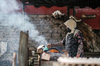 Kota Bharu, Malezya - 3 Temmuz 2020: Yakıt olarak hindistan cevizi kabukları kullanarak Malezya 'da yerel bir çöl yapan karı ve kocanın portresi.