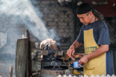 Kota Bharu, Malezya - 3 Temmuz 2020: Yakıt olarak hindistan cevizi kabukları kullanarak Malezya 'da yerel bir çöl yapan karı ve kocanın portresi.