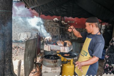 Kota Bharu, Malezya - 3 Temmuz 2020: Yakıt olarak hindistan cevizi kabukları kullanarak Malezya 'da yerel bir çöl yapan karı ve kocanın portresi.
