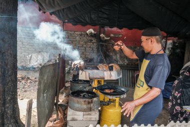 Kota Bharu, Malezya - 3 Temmuz 2020: Yakıt olarak hindistan cevizi kabukları kullanarak Malezya 'da yerel bir çöl yapan karı ve kocanın portresi.