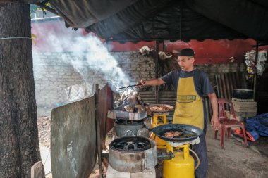Kota Bharu, Malezya - 3 Temmuz 2020: Yakıt olarak hindistan cevizi kabukları kullanarak Malezya 'da yerel bir çöl yapan karı ve kocanın portresi.