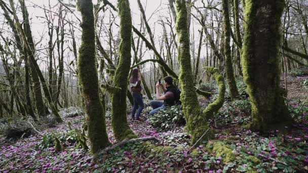 Un ragazzo scatta la foto della ragazza al telefono nella foresta e se ne vanno — Video Stock