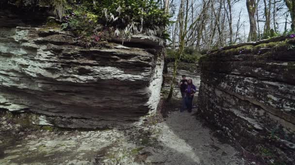 Un par de turistas se alegran de caminar en el laberinto de la montaña — Vídeos de Stock