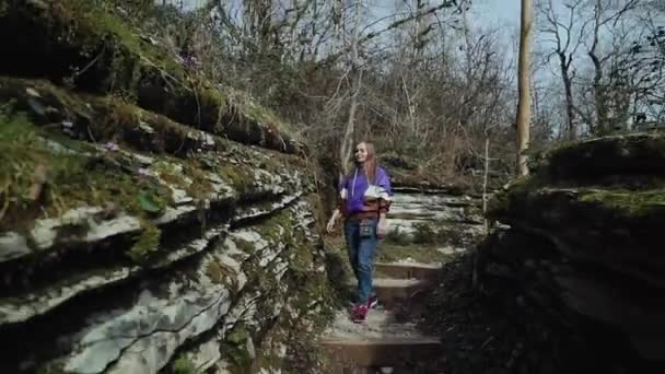 В солнечный день счастливая девушка гуляет по горному разлому — стоковое видео