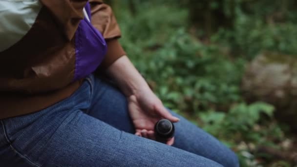 Thermo bouteille est dans les mains de la fille dans un gros plan, elle ouvre et ferme . — Video